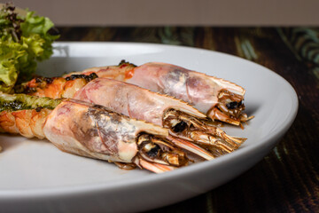 Langoustines with young potatoes. A dish with large king prawns, lobsters with vegetables. Seafood with a panel, a delicious seafood delicacy, a source of omega 3