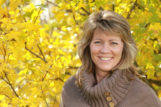 Happy mature woman with pullover in autumn