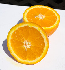 A beautiful vivd colourful juicy sliced orange, showing tasty sweet orange segments, on a white background. Vitamin C and nutritious exotic fruits.