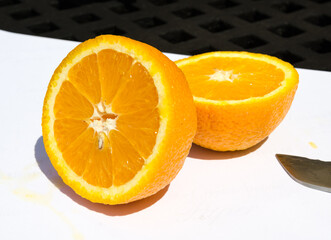 A beautiful vivd colourful juicy sliced orange, showing tasty sweet orange segments, on a white background. Vitamin C and nutritious exotic fruits.