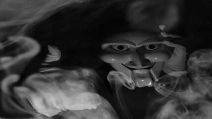 White scary mask on a black background with whites hand.