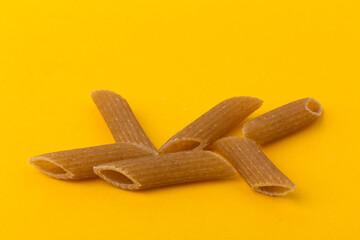 Pasta from hard wheat. Italian pasta on yellow background,  place for text.
