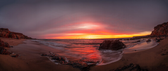 Atardecer rojo en una playa desierta