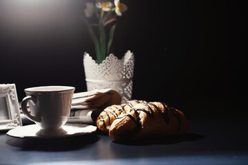 French breakfast on the table. Coffee croissant with chocolate and a decanter with cream. Fresh pastries and decaffeinated coffee.