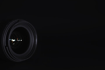 Optics to the camera on the operator’s desk. Flare in the glass of a photo lens. Background with the technique of the photographer.