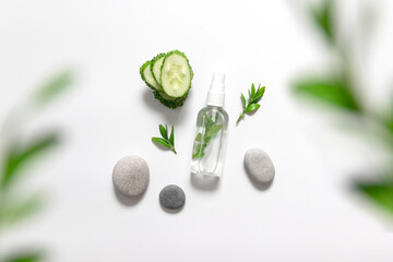 Natural organic cosmetics lay flat. Transparent cleansing gel, cucumber slice, round stones on a gray background. Layout, free space for text.