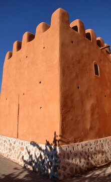 Old historical caly wall in Tiznit, Morocco, against blue sky