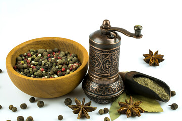 Bowl with a mixture of peppers, a mill for spices, ground black pepper isolated on a white...
