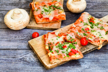  Assorted sliced italian roman   style pizza.  with parmesan cheese,  ham,  mushrooms and tomato sauce 