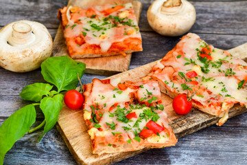  Assorted sliced italian roman   style pizza.  with parmesan cheese,  ham,  mushrooms and tomato sauce 