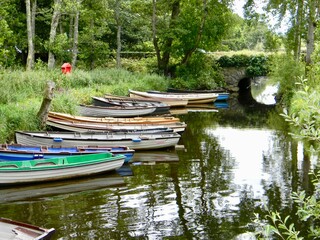 Quaint Irish landscape with colourful rowboats and stone bridge in the Irish countryside of Lough Leane near Killarney in Co Kerry Ireland