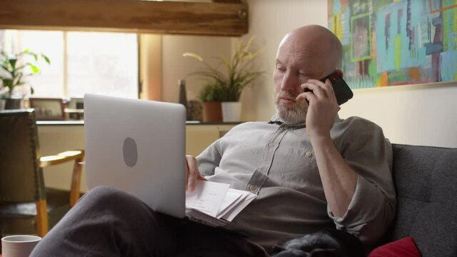 Stressed man with a laptop gets antsy while waiting on hold
