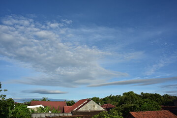 Fototapeta na wymiar Cloudy blue sky background in small village
