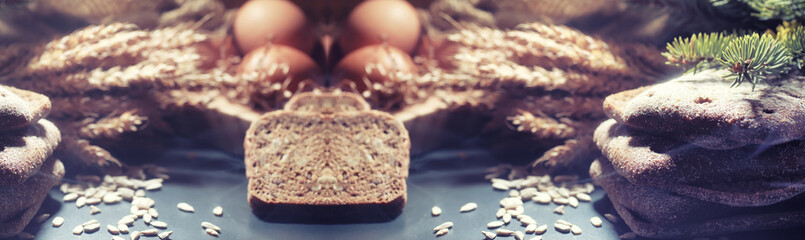 Fresh loaves of bread with wheat and gluten on a black table. Bakery and grocery concept. Fresh, healthy sorts of rye and white loaves food closeup. Fresh homemade bread with cereals.