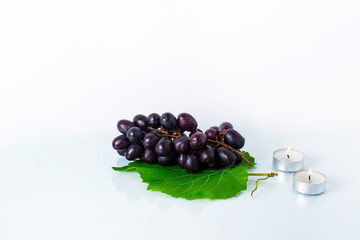 Fresh grapes on a white background with candles