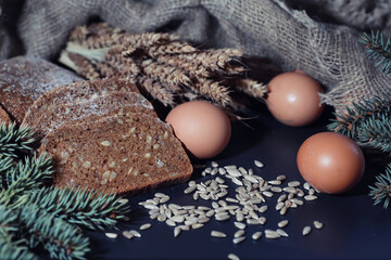 Fresh loaves of bread with wheat and gluten on a black table. Bakery and grocery concept. Fresh, healthy sorts of rye and white loaves food closeup. Fresh homemade bread with cereals.