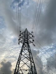 A big electric tower and white clouds behind it