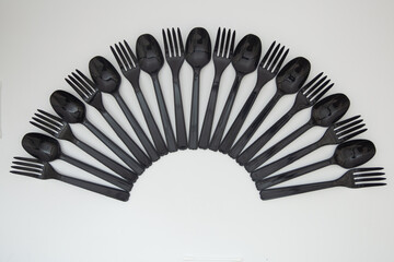 Plastic spoons and forks That is arranged in a line
