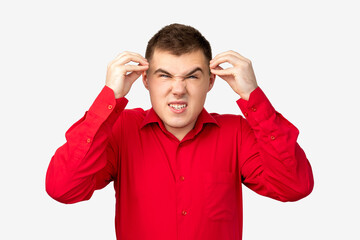Naklejka premium Frustrated man portrait. Nervous breakdown. Angry guy in red shirt touching head isolated on white background.