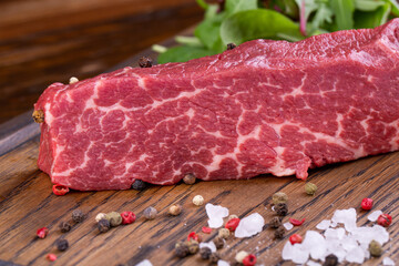 Marble beef, from which denver steak is made, with spices and greens