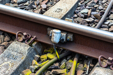 Railroad tracks lying on concrete sleepers, filling large pieces of rock, close-up on the axle...