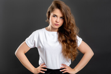 Dissatisfied woman portrait. Irritation suspicion. Confident lady with hands on hips isolated on gray.