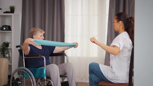 Invalid senior woman in wheelchair doing rehab with assistance from doctor. Training, sport, recovery and lifting, old person retirement home, healthcare nursing, health support, social assistance