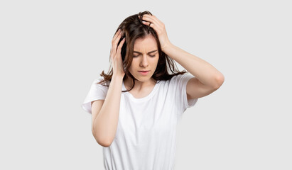 Suffering woman portrait. Migraine pain. Stressed out lady touching head isolated on neutral background.