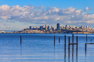 Fototapeta premium San Francisco skyline with the Bay Bridge in the background and pylons of an old pier from Sausalito, circa 2011