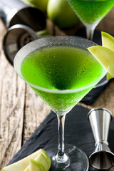 Green appletini cocktail on wooden table