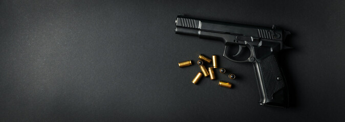 Pistol and traumatic bullets on black background. Self defense weapon - obrazy, fototapety, plakaty