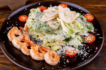 Salad with shrimp, parmesan and cherry tomatoes under cream sauce