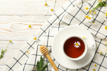 Composition with cup of chamomile tea on white wooden background