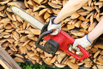 Man sawing wood with electric saw.