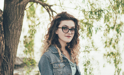 
Portrait of a girl in glasses on the beach near the river