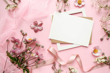Greeting card for invitation or congratulation with pink flowers and an envelope. delicate flowers on a pink background