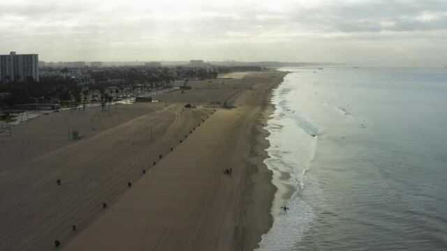 AERIAL: Flight over Venice Beach with waves in the morning, Los Angeles, California 