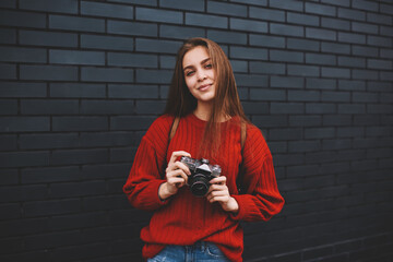 Portrait of attractive young hipster girl dressed in red sweater with copy space for brand name...