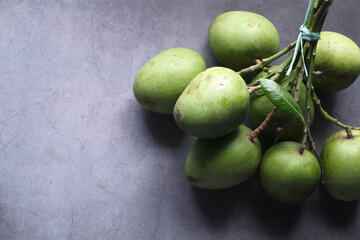 Fresh green mango on black background top down.