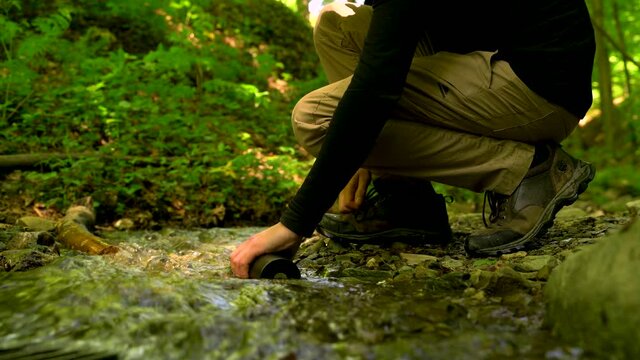 Image of man grabbing fresh river water, Medvednica mountain.