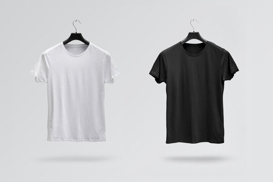 Front sides of male black and white cotton t-shirts on a hanger isolated on white background. T-shirts without print