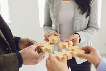Faceless business people placing puzzles together