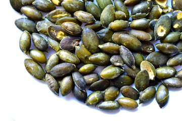 Fried delicious peeled pumpkin seeds on a white plate