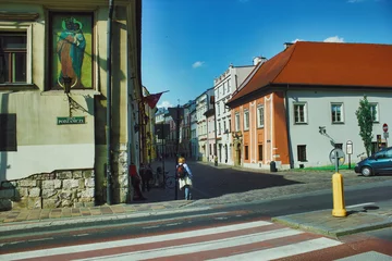 Rolgordijnen European architecture street view and a girl with a school bag, Krakow city Poland © Arpan