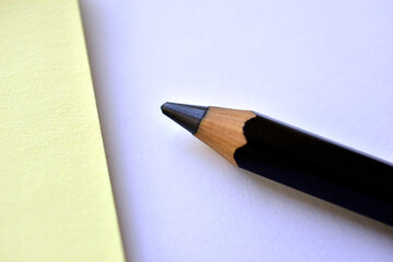 Black large pencil and Notepad on a white background