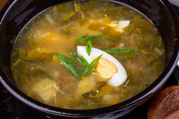 Shield with sorrel, on beef broth, with pieces of meat and boiled egg

