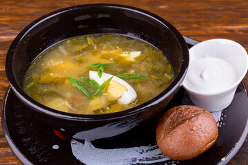 Oxalis soup with boiled egg, potatoes and green onions, served with sour cream and black bread