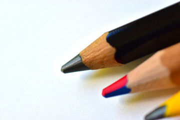 Multi-colored and large pencils on a white background