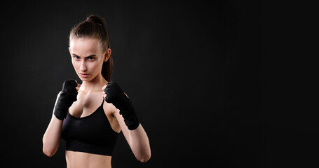 Beautiful girl in boxing gloves on a dark background