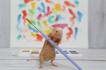 Talented animal. Mouse drawing by watercolor paints. Home artist with brush at work. Artistic pet,...